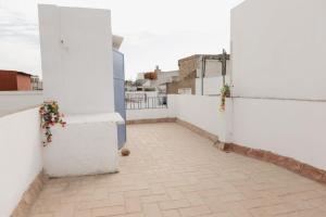 an empty balcony with white walls and flowers at Casa Las niñas in La Algaba