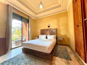 マラケシュにあるLes Jardins de la palmeraieの大きなベッドと大きな窓のある寝室 +75枚の写真