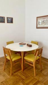 a dining room table with four chairs and a white table at Alojamiento en San Telmo in Buenos Aires