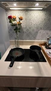 a kitchen stove with two pans and a vase of flowers at PoolAccess-rose Lahabana in Hua Hin