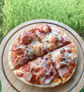 a pizza sitting on a plate on a table at Hamenameng in Ban Na Meng (1)