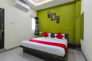 une chambre avec un grand lit avec des oreillers rouges dans l'établissement Hotel O Nabhyansh Elite Lokmanya Nagar railway station, à Indore