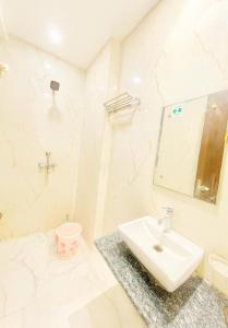 a white bathroom with a sink and a mirror at Hotel New Vintage Mathura in Mathura