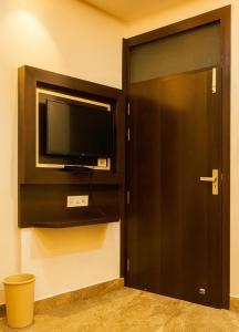 a door to a room with a tv and a door at Hotel New Vintage Mathura in Mathura