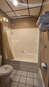 a bathroom with a white tub and a toilet at Timber Inn Motel in Phillips