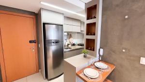 a kitchen with a stainless steel refrigerator and a table at #2905# Flat incrível– Lounge 22 | Setor Oeste in Goiânia