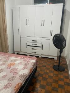 a bedroom with a bed and white cabinets and a fan at Condomínio Dom Francisco in Belém
