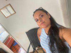 a woman sitting in a chair looking at the camera at Condomínio Dom Francisco in Belém