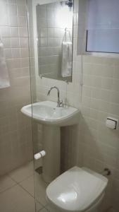 a bathroom with a toilet and a sink and a mirror at Hospedagem de Jesus in Aparecida