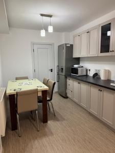- une cuisine avec une table, des chaises et un comptoir dans l'établissement Apartament Brazdă, à Craiova 22 autres photos