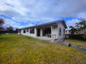 a white house with a large yard at Luxmore Lookout in Te Anau