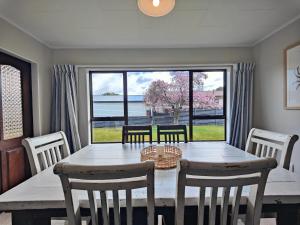 a dining room with a table and chairs and a large window at Luxmore Lookout in Te Anau