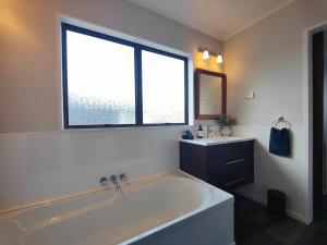 a large white bath tub in a bathroom with a window at Luxmore Lookout in Te Anau +18 photos
