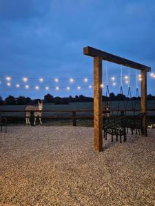 a playground with a swing and a dog in the background at Blackditch hideaway cabin in Kildare