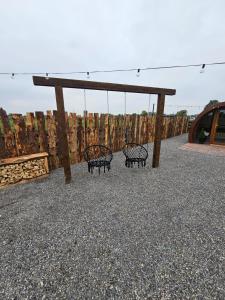 two benches sitting under a pavillion with a swing at Blackditch hideaway cabin in Kildare +10 photos