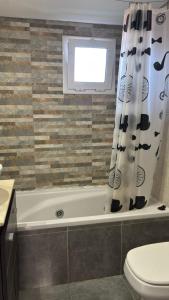 a bathroom with a tub and a toilet and a window at Latitud 28 in Mar Azul +18 photos