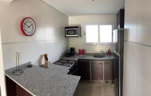 a small kitchen with a clock on the wall at Latitud 28 in Mar Azul