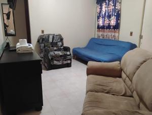 a living room with a couch and a bed at Hostal casa de los delfines in Puerto Villamil