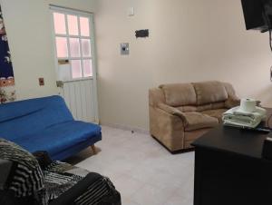 a living room with a couch and a chair at Hostal casa de los delfines in Puerto Villamil