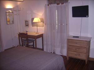 梅達的住宿－Agriturismo Il Casotto，一间卧室配有一张桌子和一张床,一张桌子和一盏灯