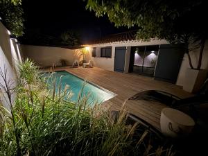 イストルにあるUn Petit Coin de Provence - Istres - Maison Contemporaine Avec Piscine Privée Chauffée, Entre Plages Et Provence, Borne 11 kWの夜間のスイミングプール付きの裏庭