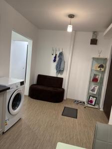 un salon avec un canapé et une machine à laver dans l'établissement Apartament Brazdă, à Craiova