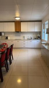 a kitchen with white cabinets and a table and chairs at Votre Maison Lointaine in Pantin