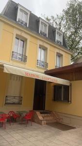a building with red tables and chairs in front of it at Votre Maison Lointaine in Pantin