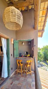 a kitchen with two yellow chairs and a table at Casa de Hóspedes da Lili & André in Caraíva