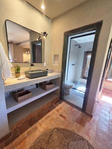 a bathroom with a sink and a mirror at Casa de Hóspedes da Lili & André in Caraíva