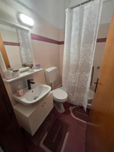 a bathroom with a white toilet and a sink at Studio Violet Olympic beach in Olympiaki Akti +27 photos