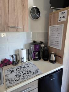 a kitchen counter with a coffee maker and a clock at Studio Violet Olympic beach in Olympiaki Akti