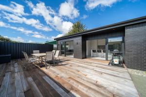 a wooden deck with a table and chairs on a house at Te Anau Lake Escape in Te Anau