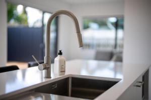a kitchen sink with a bottle of soap on it at Te Anau Lake Escape in Te Anau +26 photos