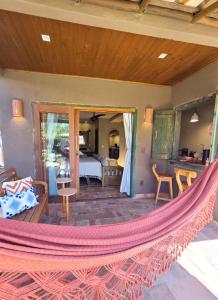 a hammock on a house with a bedroom at Casa de Hóspedes da Lili & André in Caraíva +18 photos
