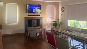 a living room with a table and a tv on the wall at paraíso la Caleta in Mar de Cobo