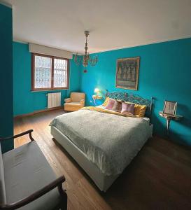 a blue bedroom with a bed and a chair at WhiteHome in Conegliano