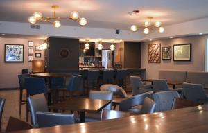 a restaurant with tables and chairs and a bar at Four Points by Sheraton Chicago Westchester/Oak Brook in Westchester