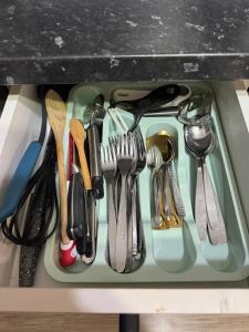 a tray filled with utensils in a drawer at Apartament Brazdă in Craiova