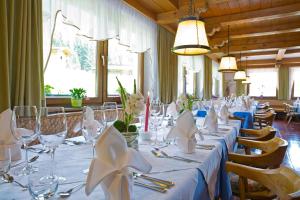 un lungo tavolo con tovaglie e tovaglioli bianchi di Hotel Waldruhe a Santa Maddalena in Casies