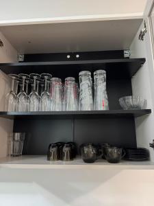 a shelf with many glass jars and bowls on it at Apartament Brazdă in Craiova
