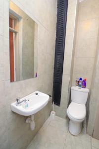 a bathroom with a toilet and a sink at Kiambu cozy studio in Kiambu +18 photos