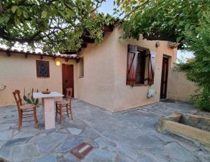 a patio with a table and chairs next to a building at Fay's Guesthouse Aegina in Egina