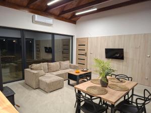 a living room with a couch and a table and chairs at Dom nad jeziorem Winna Górka 