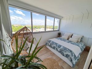 una camera da letto con un letto e una grande finestra di Appartement La Pergola a La Grande-Motte
