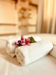 two towels with flowers on top of a bed at Casa Baly Jericoacoara in Jericoacoara