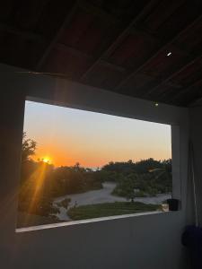 a window in a room with a view of a sunset at Casa Baly Jericoacoara in Jericoacoara