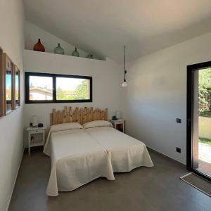 Un dormitorio con una gran cama blanca con dos ventanas. en Los Castaños, en La Alberca
