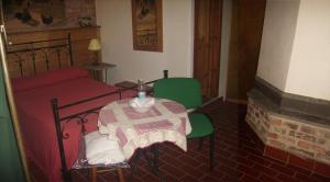 um quarto com uma mesa e uma cama e uma mesa e cadeiras em Agriturismo Il Casotto em Maida