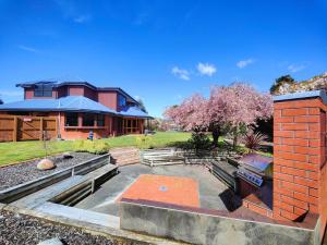 a house with a yard with a brick building at Grand Getaway Te Anau in Te Anau